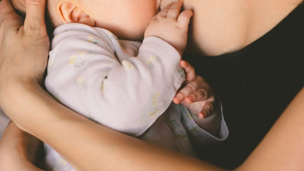 Mãe segurando o bebê no colo durante a amamentação